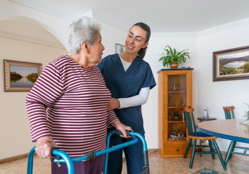 home-caregiver-helping-a-senior-woman-using-a-walker-at-home
